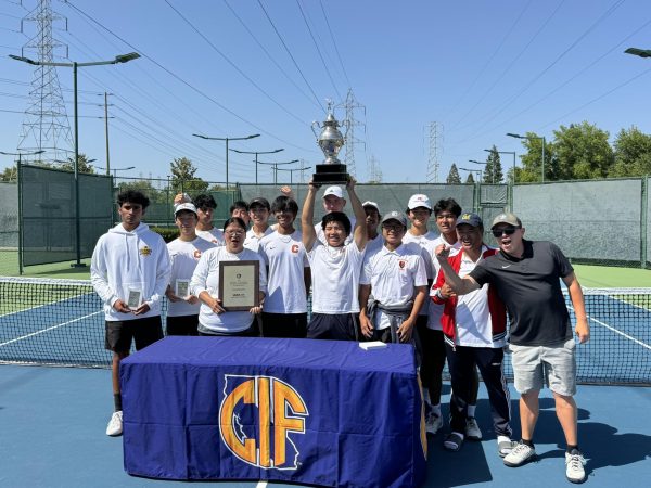 Sophomore Vincent Le raises the Northern California team championship trophy while surrounded by his teammates after Cal High’s 6-1 victory over Homestead High in Folsom on May 19. Cal finished runner up to the state title.