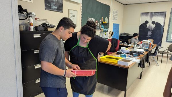 New photo teacher Angelique Mcintosh, right, looks at test strips from senior Sean Davis, helping him determine which of his photos he should use during the Advanced Photo class. Mcintosh previously taught at Golden View Elementary.