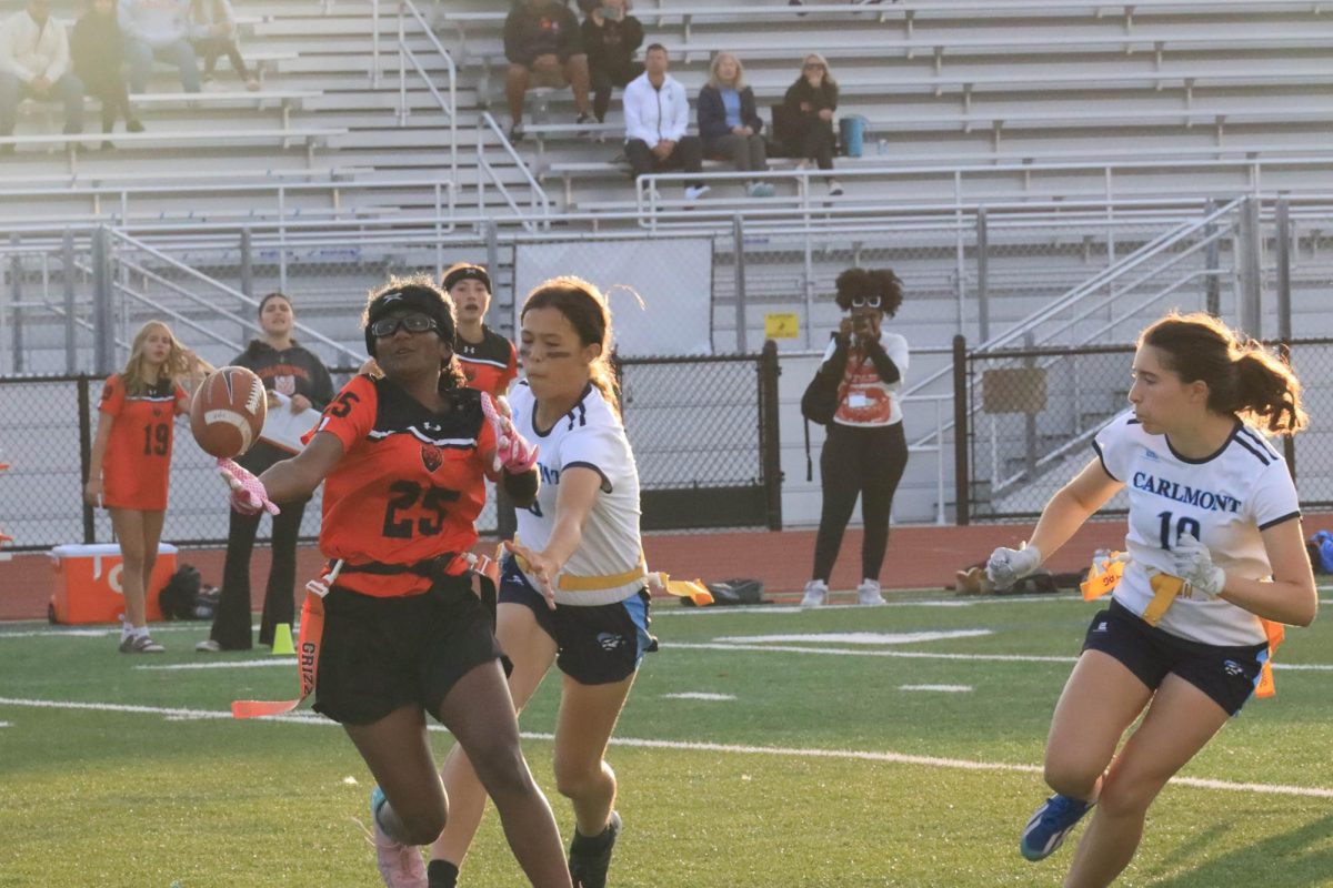 Cal High freshman Adithi Chennavaram, left, catches the ball while dodging Carlmont defender Jeanette Healey during the Grizzlies’ JV flag football game on Sept. 16.   