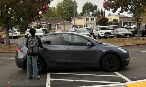 Cal High student gets into their Tesla Model Y car at the front of the school. Tesla cars are very popular in the Bay Area.        